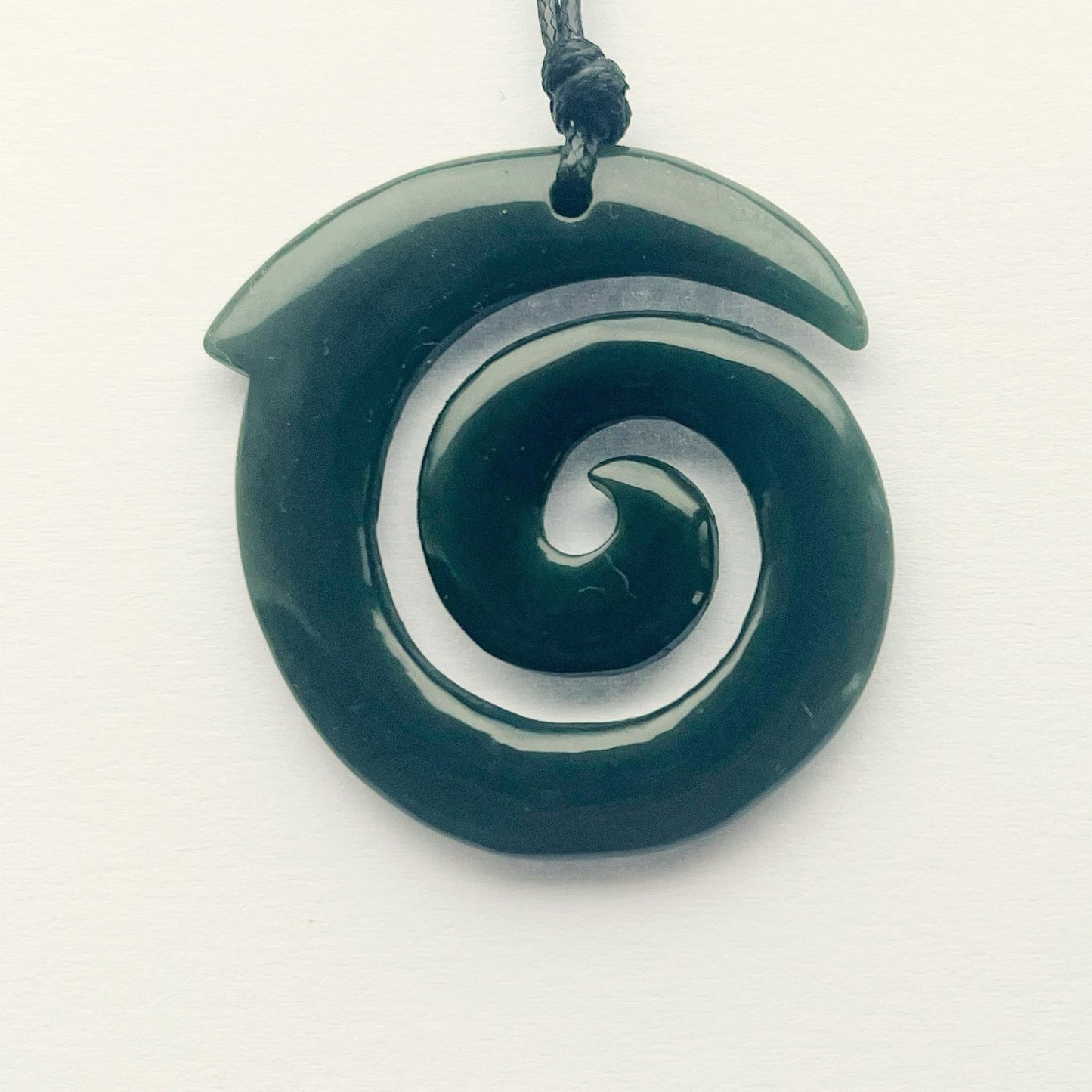 Carving Studio NZ greenstone pounamu koru pendant 43mm with adjustable cord on white background