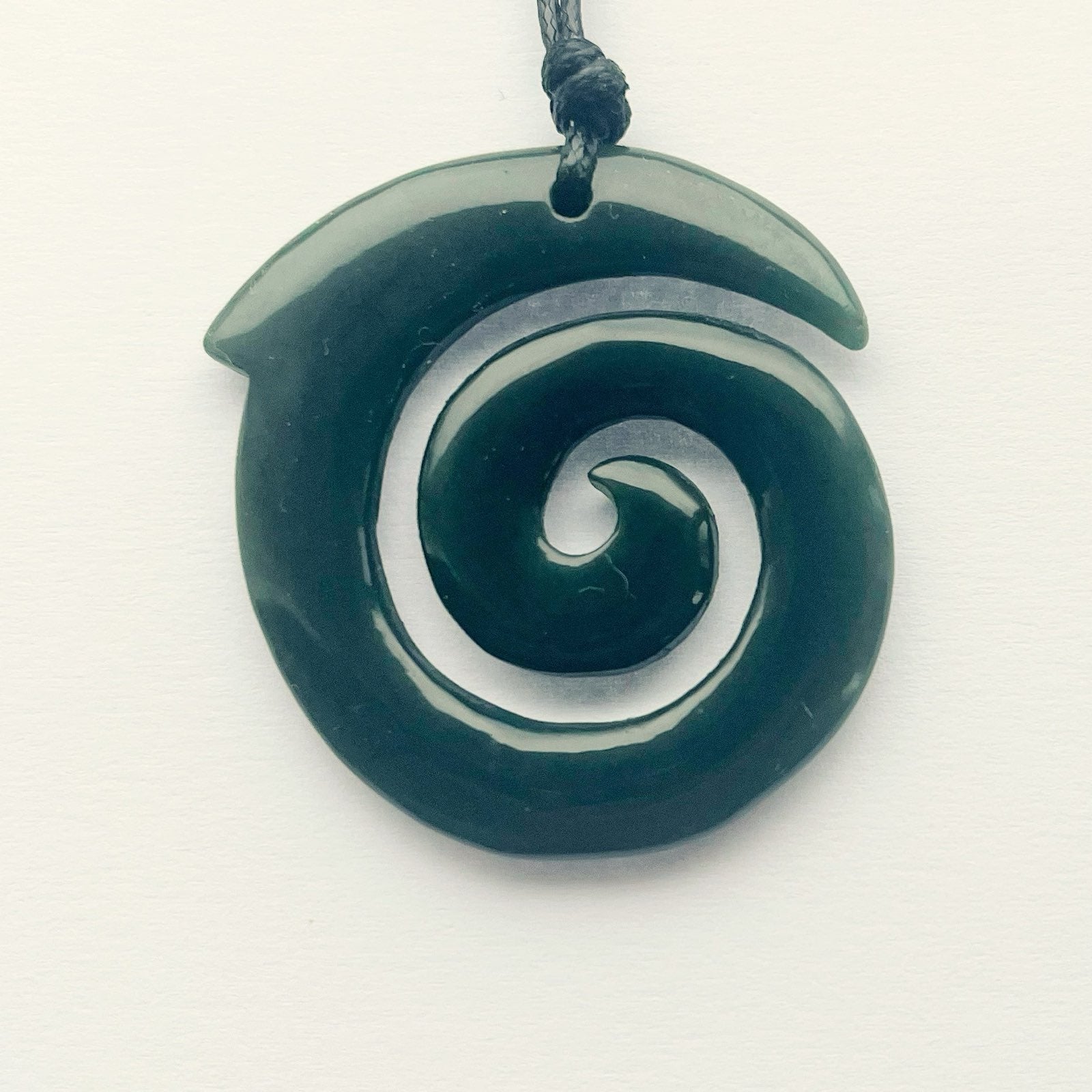 Carving Studio NZ greenstone pounamu koru pendant 43mm with adjustable cord on white background